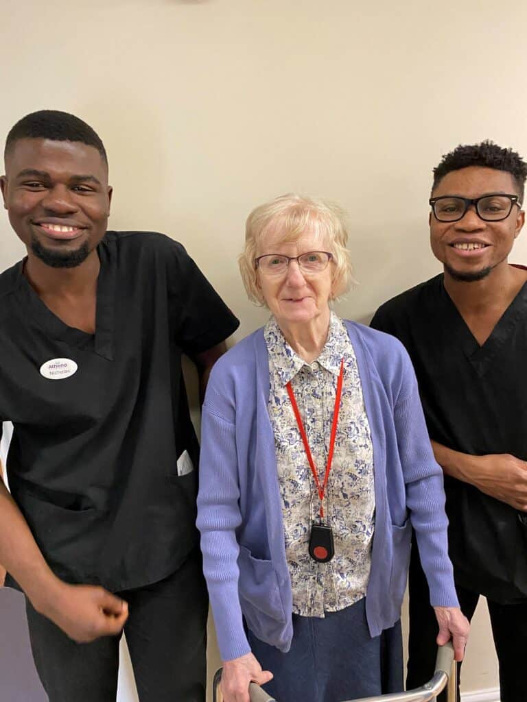 Two male nurses with resident in care home